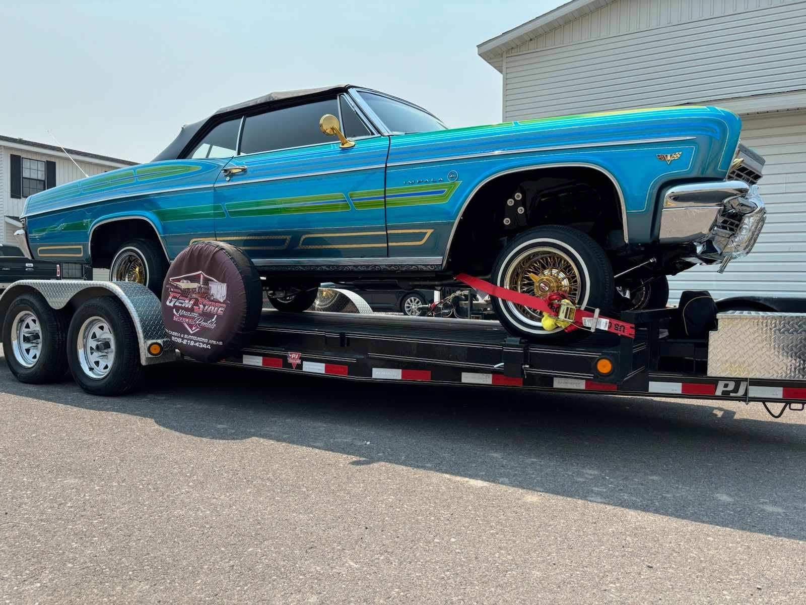 Classic blue Chevrolet Impala secured on a Gem State Haulers car trailer